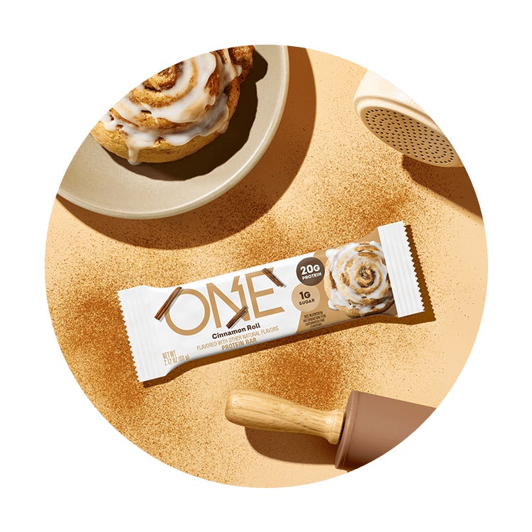 one bars cinnamon roll flavored protein bar surrounded by flavor cues